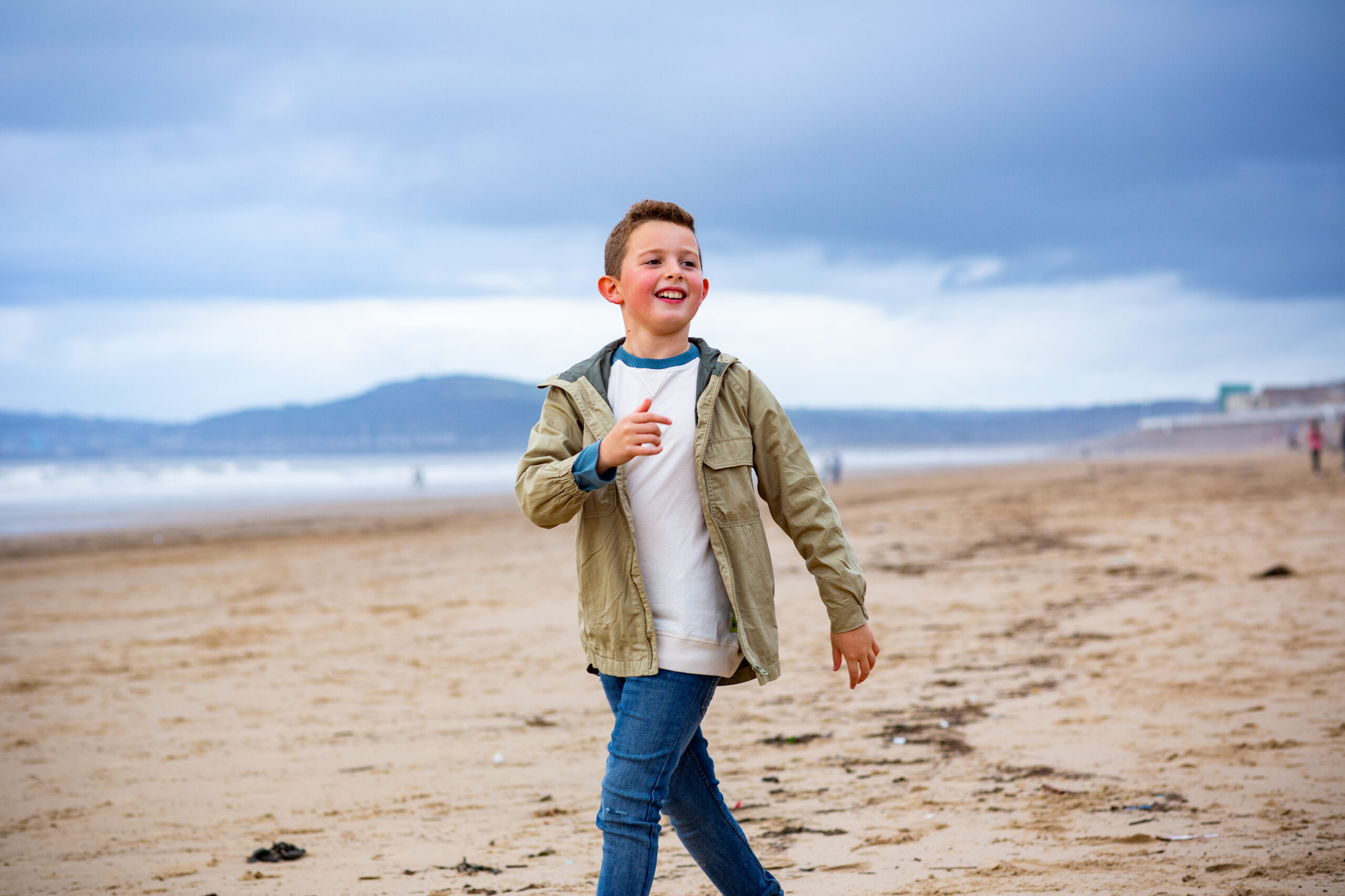 Boy on beach at aberavon looking out to swansea bay