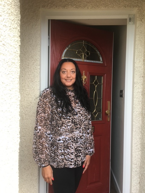 Nina standing at her front door