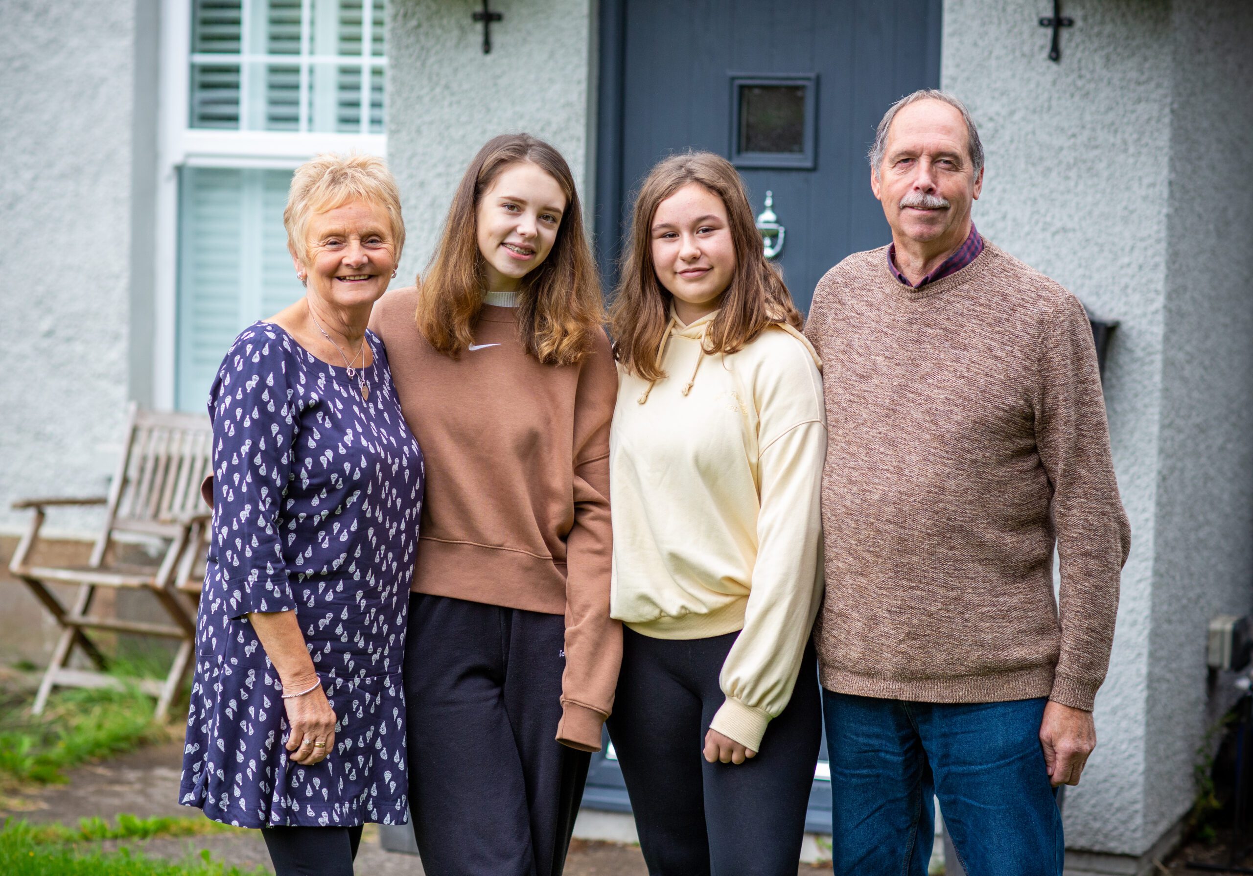 Family outside front door of house